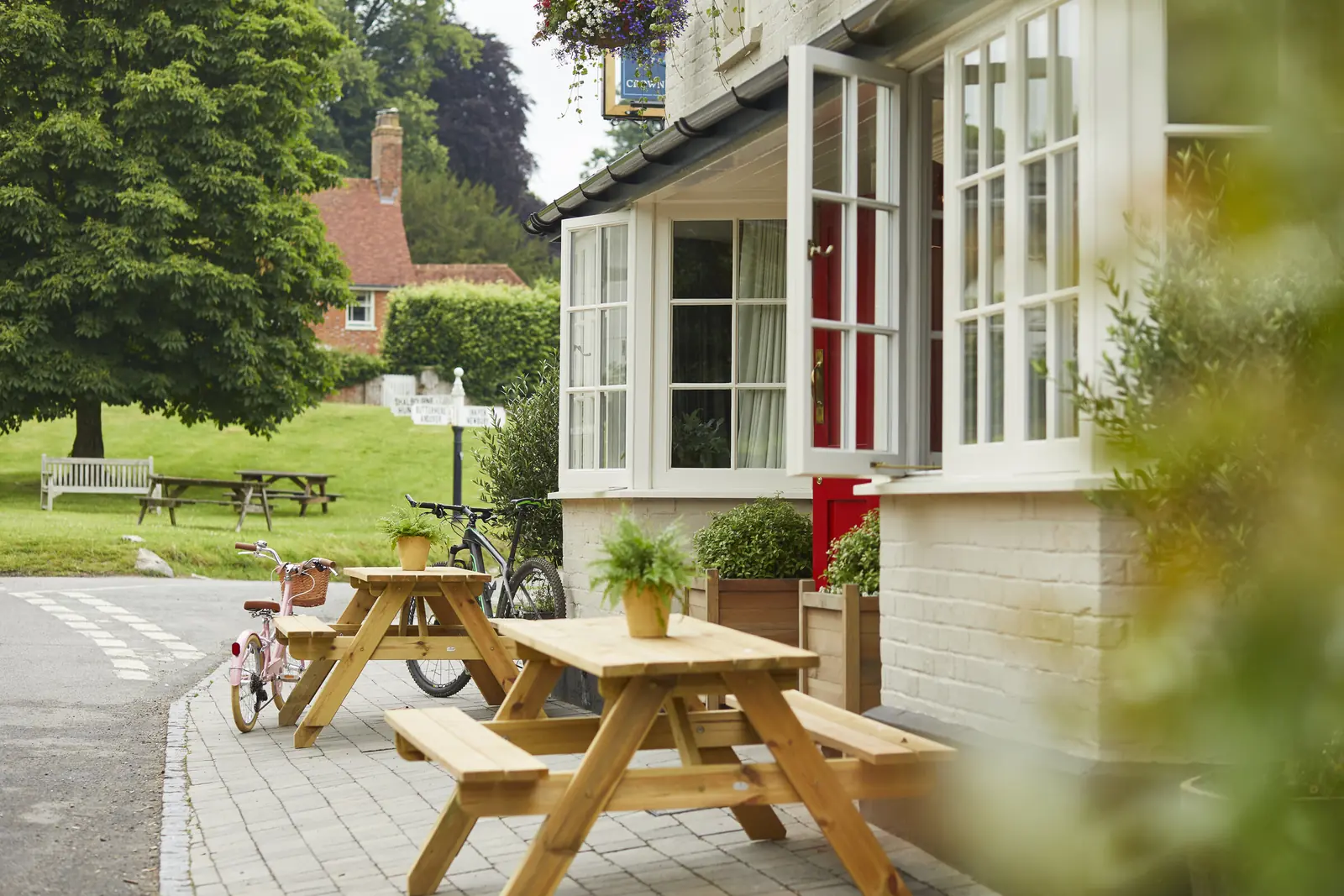 Picnic benches outside the pub, looking over the village green
